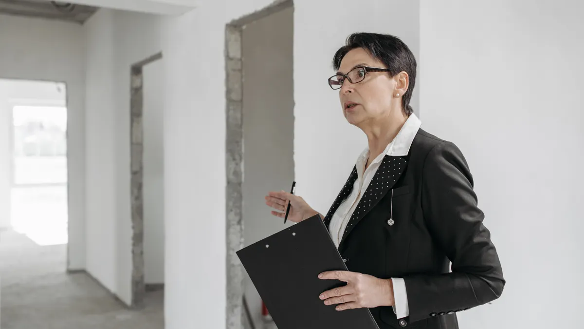 Inspector in an unfinished interior with clipboard