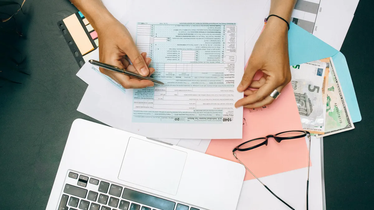 Financing and budgets for first flips — The Complete Guide Hands with budget forms, calculator, laptop, and cash