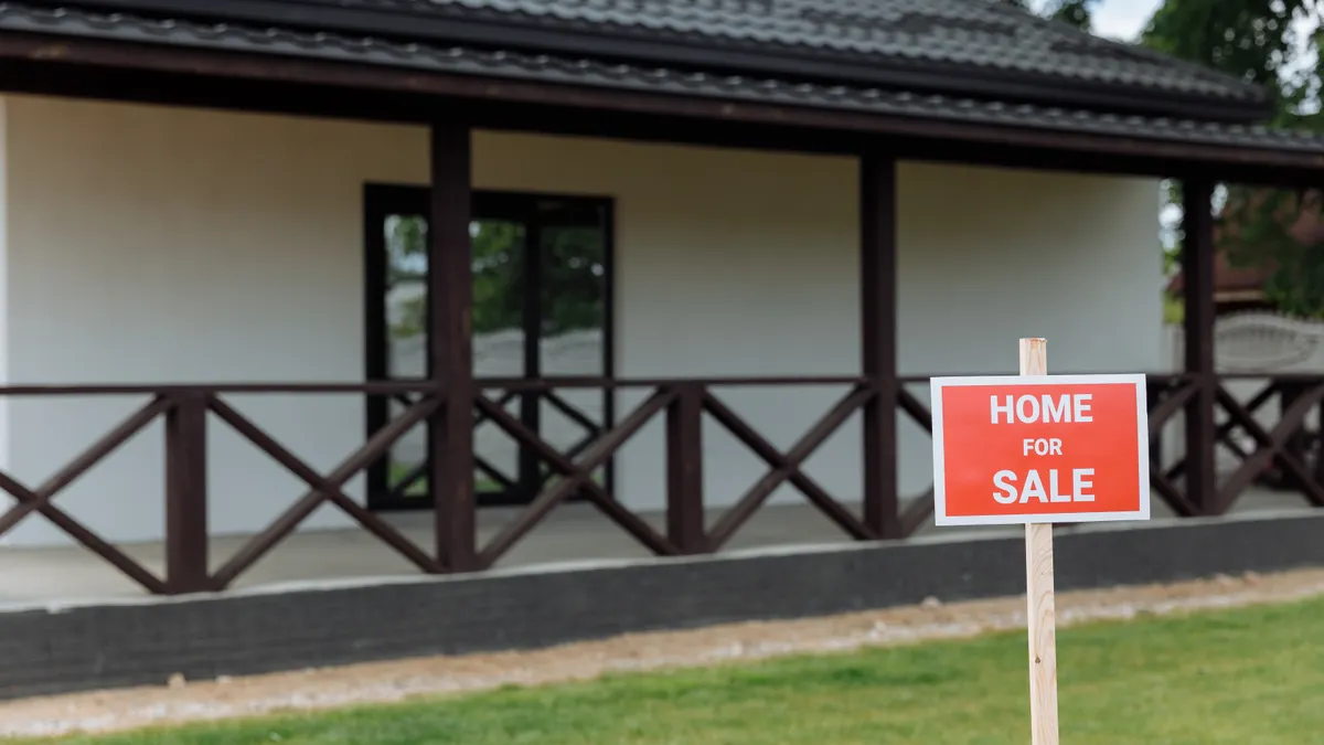 Home for sale sign by a house