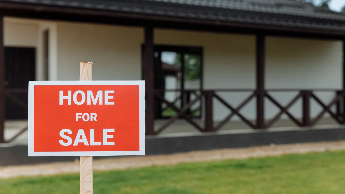 Home for sale sign in front of a house