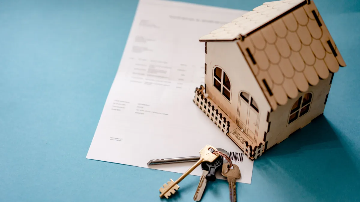 Model house on papers with a set of keys