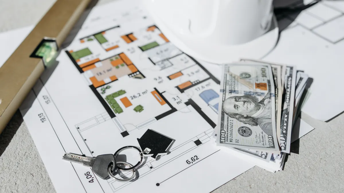Floor plan with cash, keys, and a hard hat