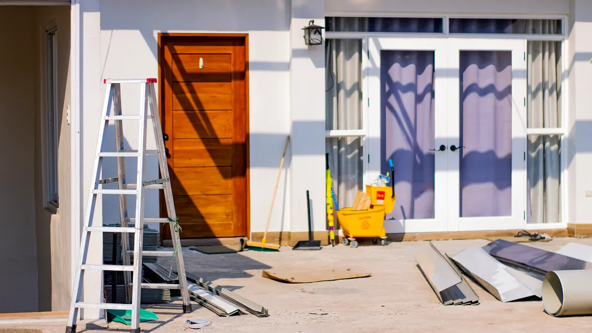 House exterior under renovation with ladder and tools