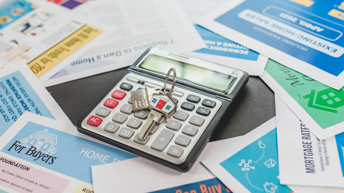 How Much Money Do You Need to Start Flipping Houses? Calculator with house keys and real estate flyers
