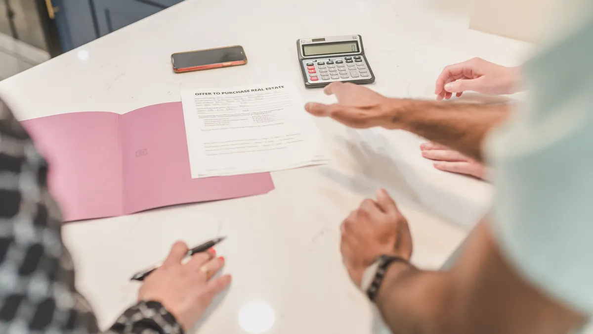 People reviewing documents with a calculator